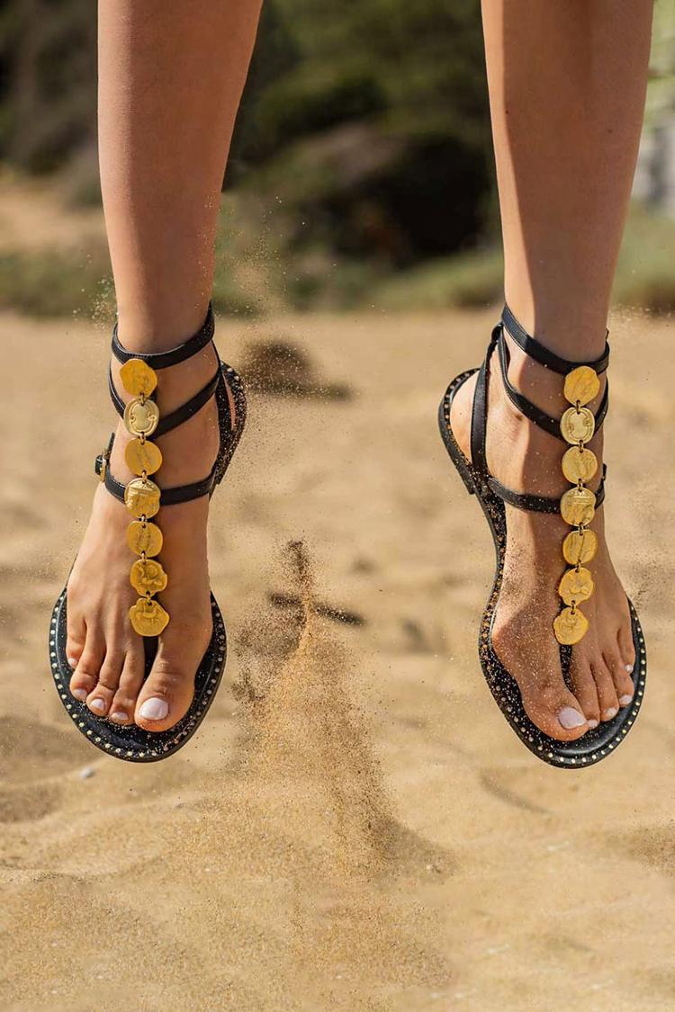 Sandalias negras con tira al tobillo, hebilla y detalle metálico irregular